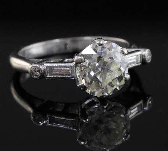 A mid 20th century 18ct white gold and single stone diamond ring with baguette cut diamond set shoulders,